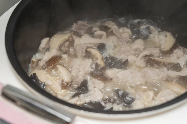 Приготовление риса со свиным грибом и черным грибом — стоковое фото