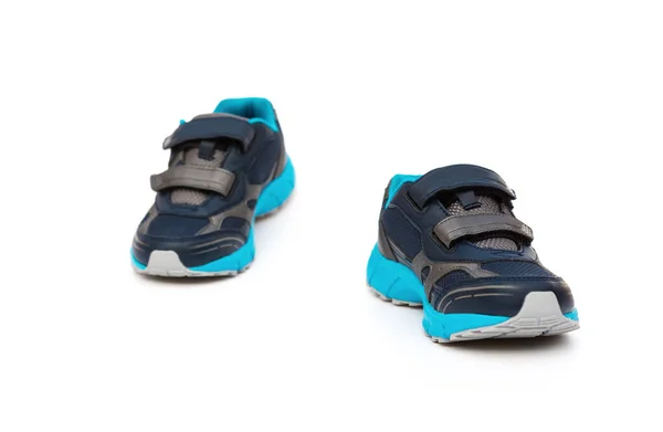 Par de zapatos deportivos azules y negros para niños sobre fondo blanco — Foto de Stock