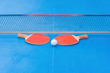 pingpong raket ve top ve bir mavi pingpong tablo net