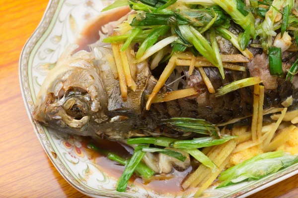 Φρέσκο ψάρι αχνιστό ολόκληρο καλυμμένο με βότανα κρεμμύδια και σάλτσα εσωτερικη — Φωτογραφία Αρχείου