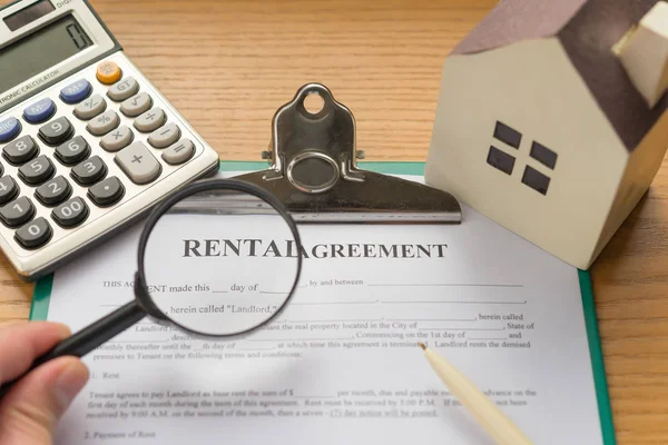 Rental agreement contact with an architectural model and a calculator and magnifier with rental highlighted — Stock Photo, Image