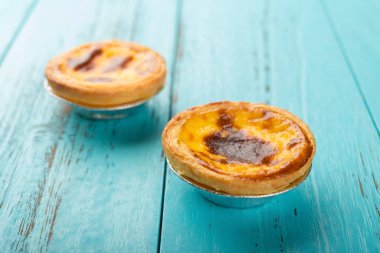 Stüdyo ateş Portekizce yumurta tart ahşap arka plan üzerinde