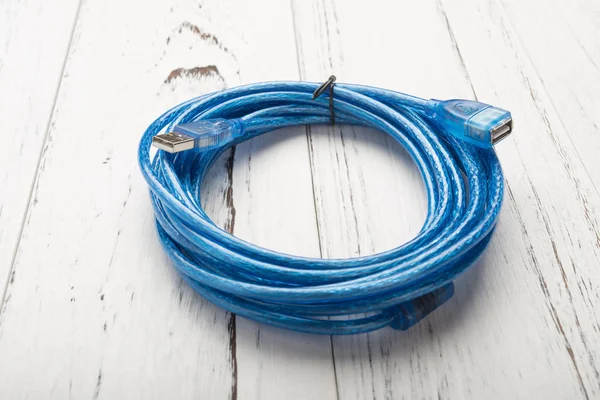 Blå USB-kabel på en vit trä bakgrund — Stockfoto