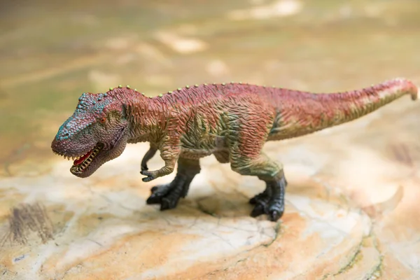 Tyranozaur zabawka na skale — Zdjęcie stockowe