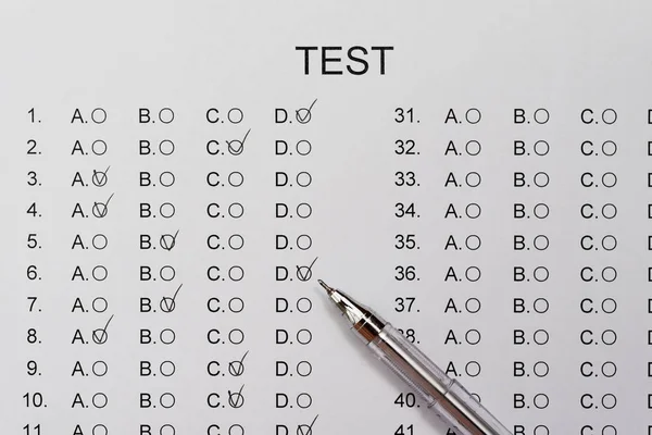 Test score sheet with answers and ballpoint close up — Stock Photo, Image