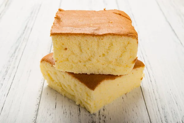 Seitenansicht zwei Biskuitkuchen auf weißem Holz Hintergrund — Stockfoto