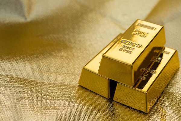 three pieces of gold bars on a golden background