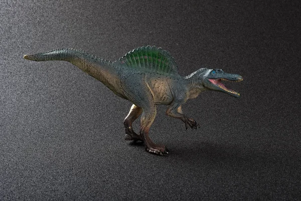 Spinosaurus brinquedo em um fundo escuro — Fotografia de Stock