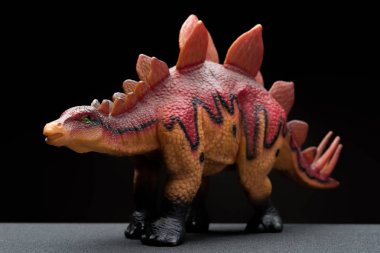 karanlık bir arka plan üzerinde kahverengi stegosaurus oyuncak
