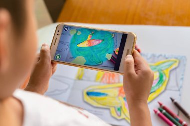 Augmented Reality popup resim yolu ile hareket eden dolu bir yunusun oynayan çocuk