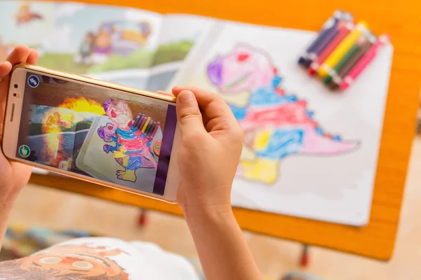 Kid playing Augmented Reality popup paintings of a filled dinosaur via mobile — Stock Photo, Image