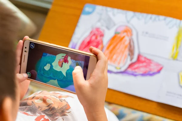 Ребенок играет дополненной реальности всплывающие картины заполненного пингвина через мобильный телефон — стоковое фото