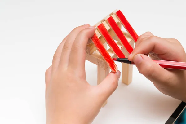 Niño haciendo pintura de color para un modelo de casa de madera — Foto de Stock