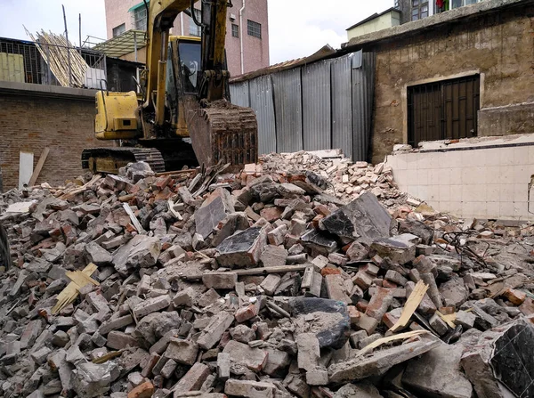 Demolished concrete and brick rubble debris with excavator — Stock Photo, Image