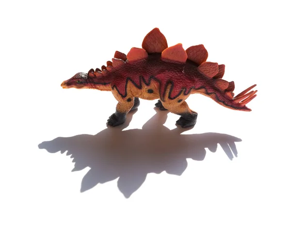 Brun stegosaurus leksak med skugga på en vit bakgrund — Stockfoto