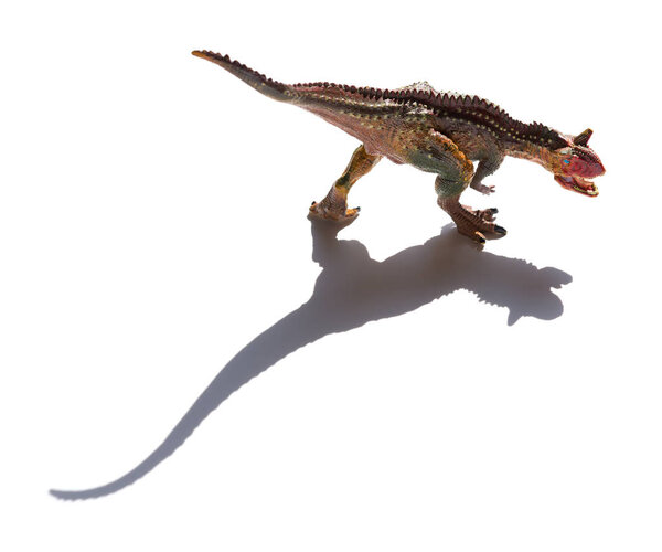 front view brown carnotaurus toy with shadow on a white background