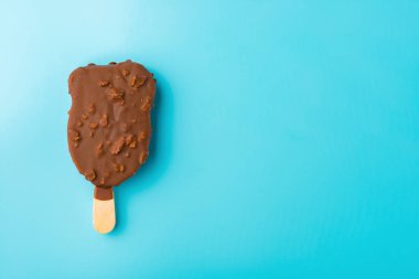 Dış çikolatalı dondurma mavi bir arka plan üzerinde erime başlar