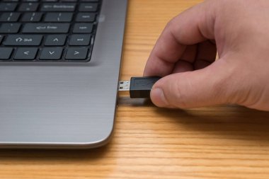 mavi bir ağ kablosu bir dizüstü için bağlantı koyarak el