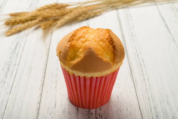 Homemade cup cake with wheat on a wood background — Stock Photo, Image