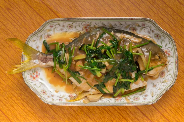 Φρέσκο ψάρι αχνιστό ολόκληρο καλυμμένο με βότανα κρεμμύδια και σάλτσα — Φωτογραφία Αρχείου