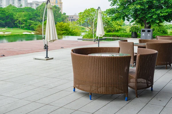 Sofa und Tisch aus Rattan im Garten mit See — Stockfoto