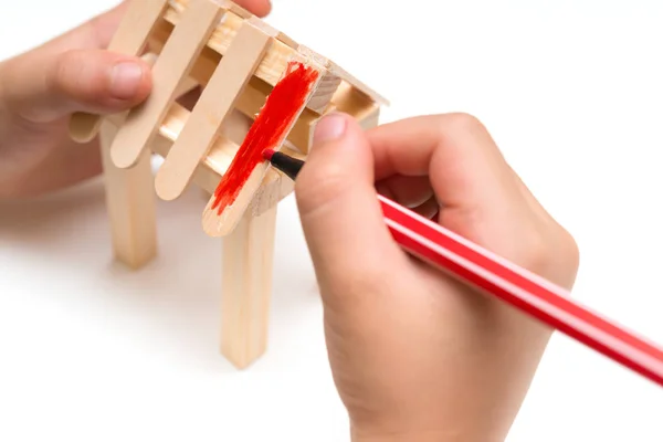 Niño haciendo pintura de color para un modelo de casa de madera —  Fotos de Stock