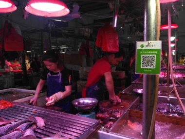 Balık perakendeci bir Wechat Qr kodu ödeme önünde Çin pazarında