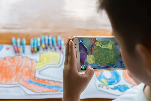 Gyerek játszik a bővített valóság lakosság festmények szín tele nagy fal mobiltelefonon — Stock Fotó