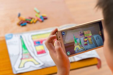 Augmented Reality popup resim dolgulu zafer ve Eyfel Kulesi'ne kemer yolu ile hareket eden oynayan çocuk