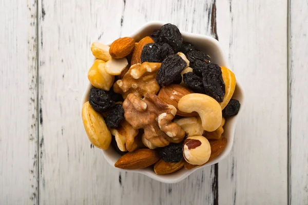 Top view almonds and walnuts and cashew nuts and raisin and dry blueberries on a white dish — Stock Photo, Image