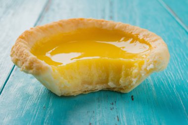 ahşap arka plan üzerinde bir ısırık ile bir yumurta tart stüdyo çekimleri yakın çekim