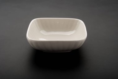 kare şekli boş seramik tabak siyah bir arka plan üzerinde