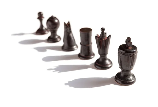 Black chesses line up on a white background with shadows — Stock Photo, Image