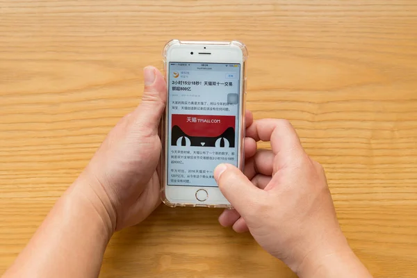 Man reading mobile news saying Tmall sales more than 80-billion RMB in 2 hours 15 minutes 18 seconds in the Chinese online shopping day on November 11 — Stock Photo, Image