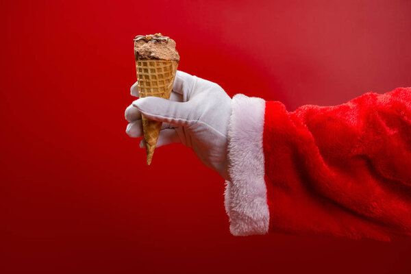 santa claus holding an ice cream cone with a bite on red