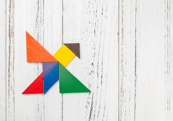 wooden tangram shaped like a flying bird with copy space