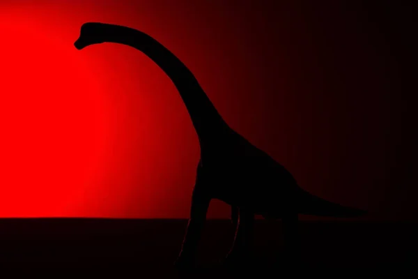 ブラキオサウルス暗闇の中で赤色の光と影 — ストック写真