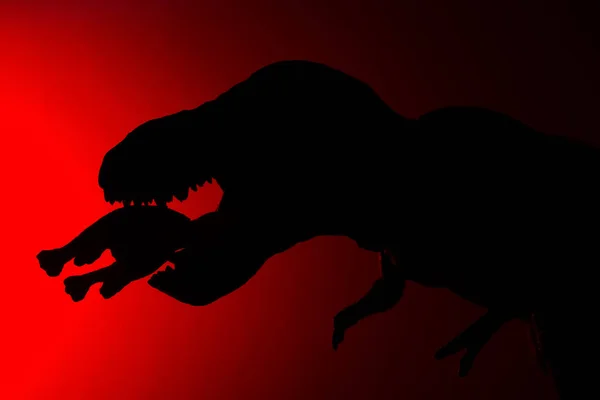 Sombra Tiranosaurio Mordiendo Dinosaurio Más Pequeño Con Luz Roja Oscuridad — Foto de Stock