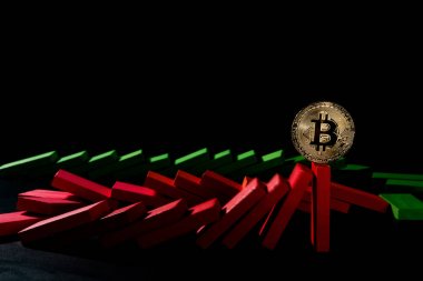 düşen dominos bitcoin ayakta mali bir kavram olarak siyah arka plan üzerine