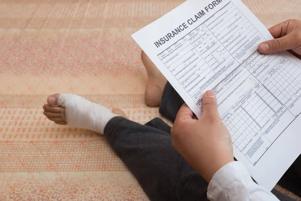 Hombre Con Pie Envuelto Sentado Cama Leyendo Formulario Reclamación Seguro — Foto de Stock