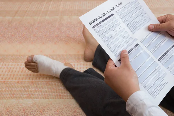 Hombre Con Pie Envuelto Sentado Cama Leyendo Formulario Reclamo Lesión — Foto de Stock