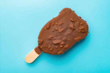 Dış çikolatalı dondurma mavi bir arka plan üzerinde erime başlar