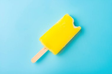 mavi bir arka plan bir ısırık ile sarı buzlu şeker