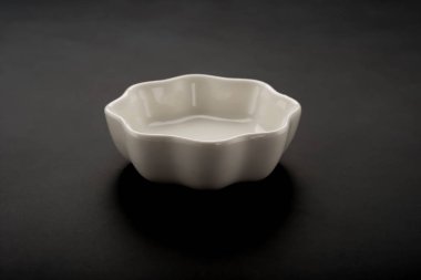 çiçek şekli boş seramik tabak siyah bir arka plan üzerinde