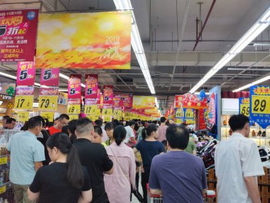 Zhongshan Çin-3 Kasım 2019: İnsanlar alışveriş merkezinde alışveriş yapıyor ve% 50 indirimli alışveriş merkezinde birçok şey satılıyor..