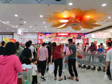 Zhongshan Çin-3 Kasım 2019: İnsanlar alışveriş merkezinde alışveriş yapıyor ve% 50 indirimli alışveriş merkezinde birçok şey satılıyor..