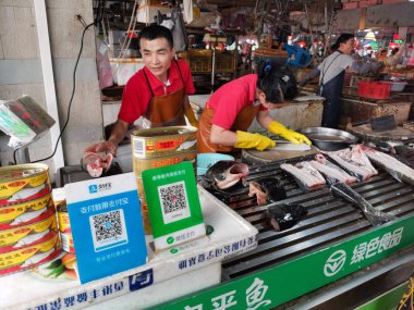 Zhongshan, Çin-3 Kasım 2019: Çin pazarında Wechat ve Alipay Qr kodlu balık perakendecisi.