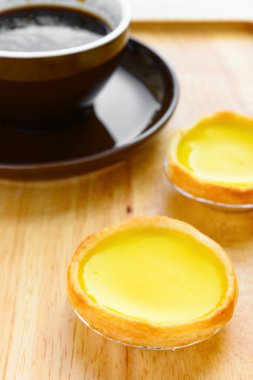 Sırtında bir fincan kahve olan taze yumurtalı tartlar.