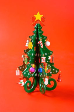 Güzel Noel ağacı kırmızı arka planda dikey kompozisyonda dönüyor
