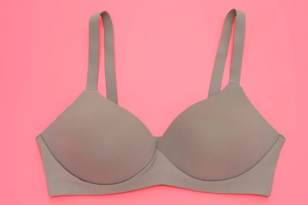 beige bra for women on a pink background